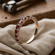 Gold ring with red crystal inlays